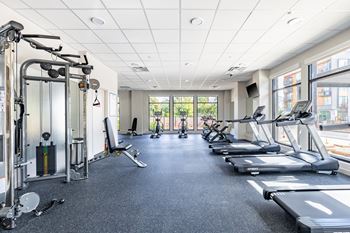 A spacious gym with treadmills, weights, and exercise equipment.